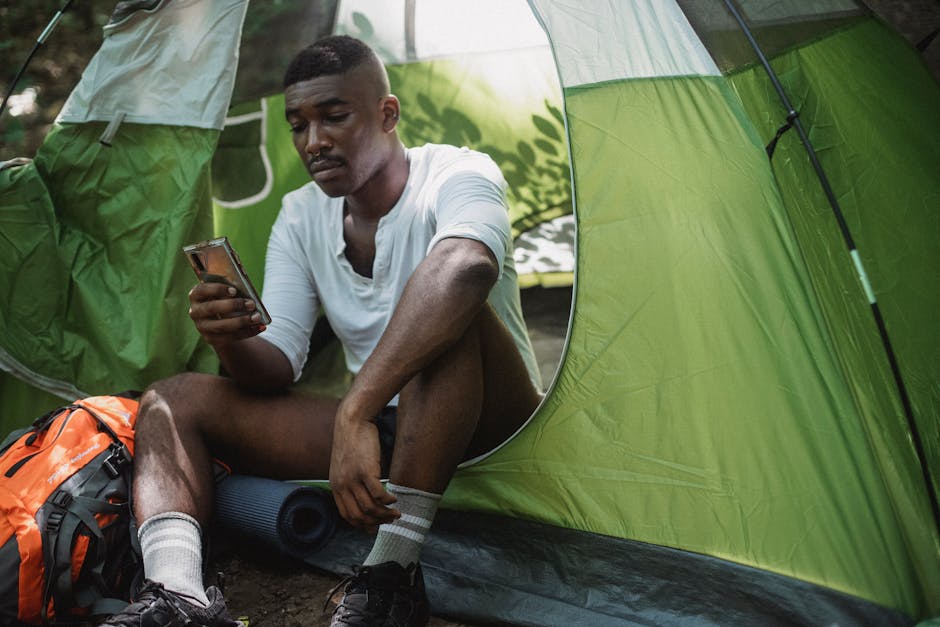 Man inside tent with phone